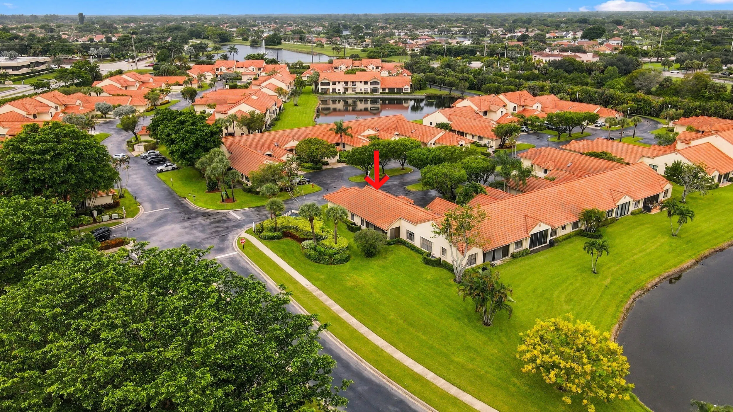 Community featuring terracotta tile roofs, mature landscaping, and waterside properties
