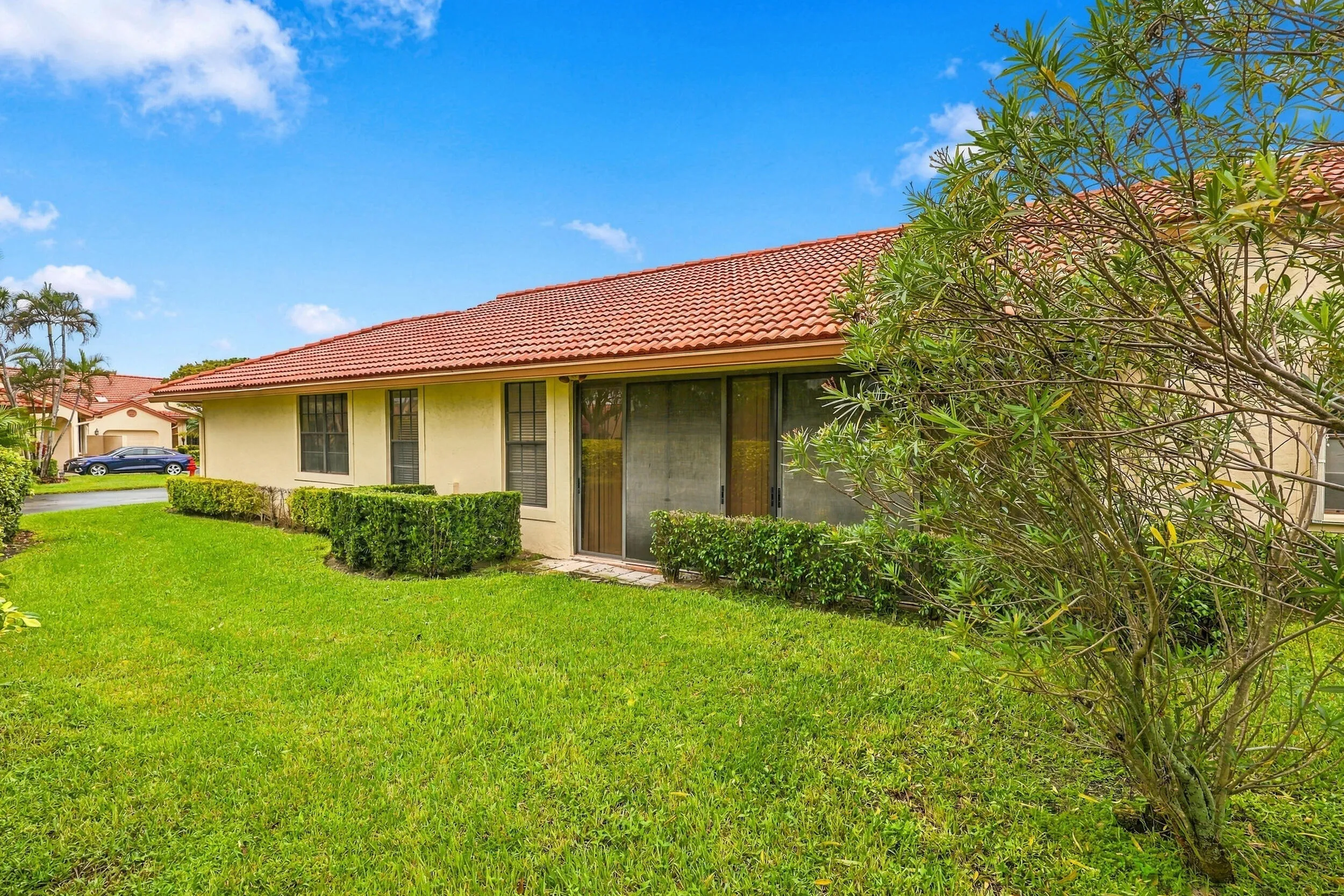 Exterior featuring a red tile roof, stucco siding, and a screened patio