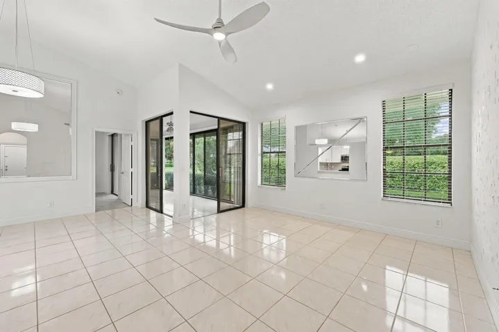 Vaulted ceilings, recessed lighting, ceiling fan, and large windows with blinds