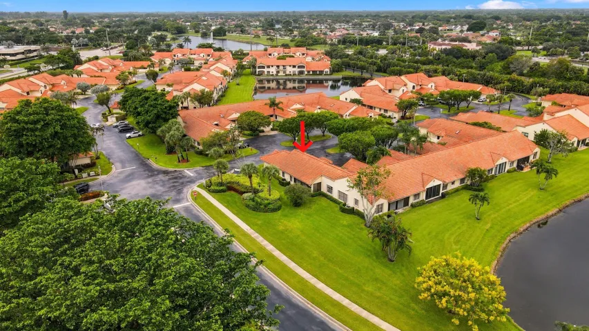 Community featuring terracotta tile roofs, mature landscaping, and waterside properties