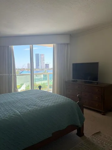 Expansive glass sliding doors with water and distant cityscape scenery