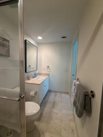 Vanity with an integrated sink, framed mirror, and recessed lighting