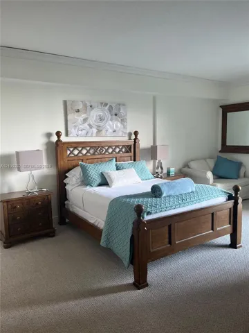 Wall-to-wall carpeting, crown molding, and neutral wall tones
