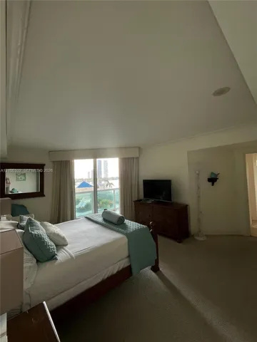 Wall-to-wall carpeting, recessed ceiling lighting, crown molding, and a full-height window with drapery