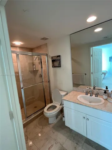 Walk-in shower with clear glass enclosure and tile surround