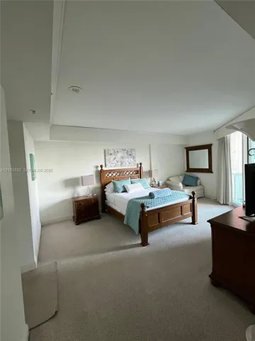 Wall-to-wall carpeting with an integrated wall niche, recessed lighting, and a large window with vertical blinds