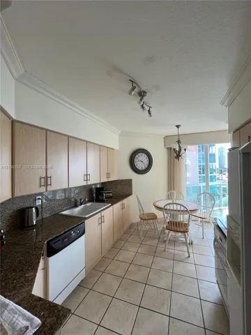 Tile flooring, track lighting, crown molding, built-in dishwasher, and a double basin sink