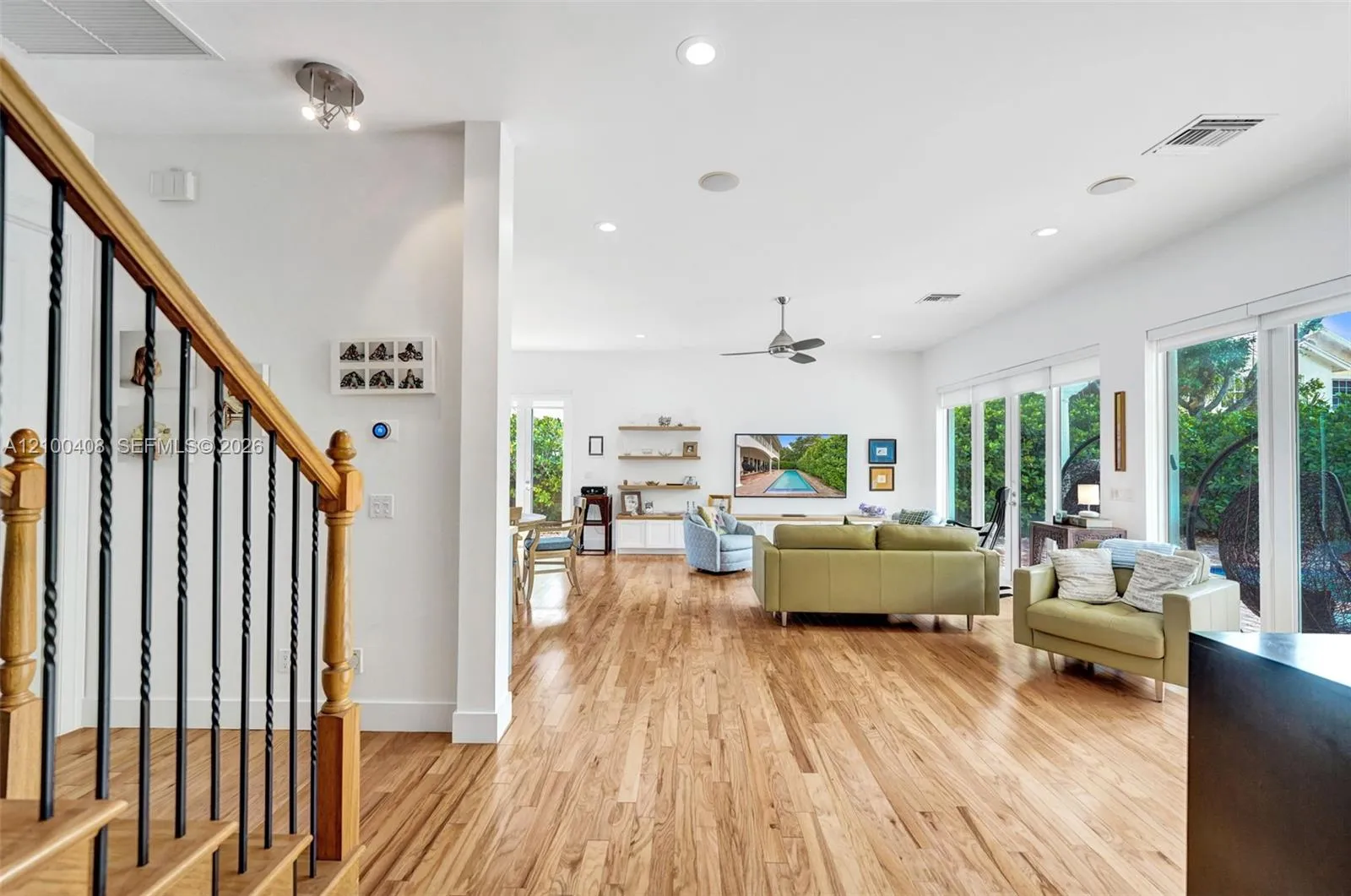 Large, open living room with all impact windows and sliding glass doors out to the pool/patio.
