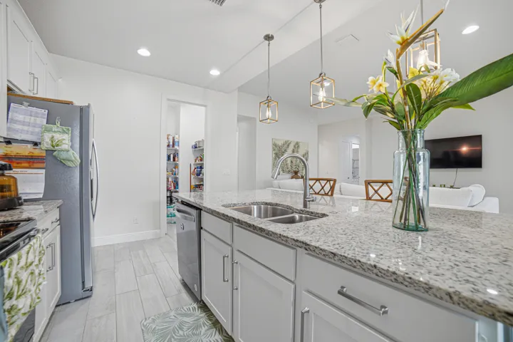 Kitchen featuring a dual basin sink, white cabinetry, a pantry with shelving, and recessed lighting