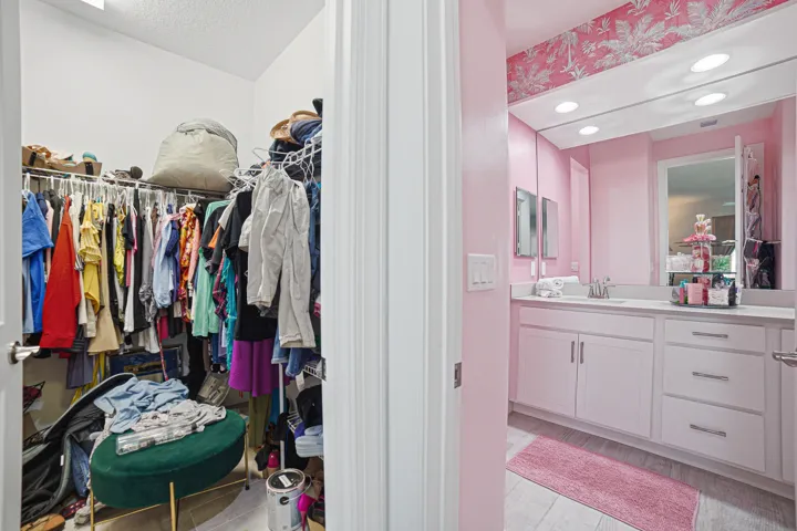 Bathroom featuring a double vanity with white cabinetry, integrated sinks, and a large wall-mounted mirror