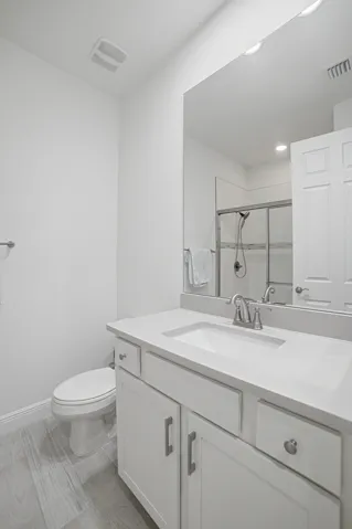 White vanity with a rectangular undermount sink, brushed nickel faucet, and integrated countertop