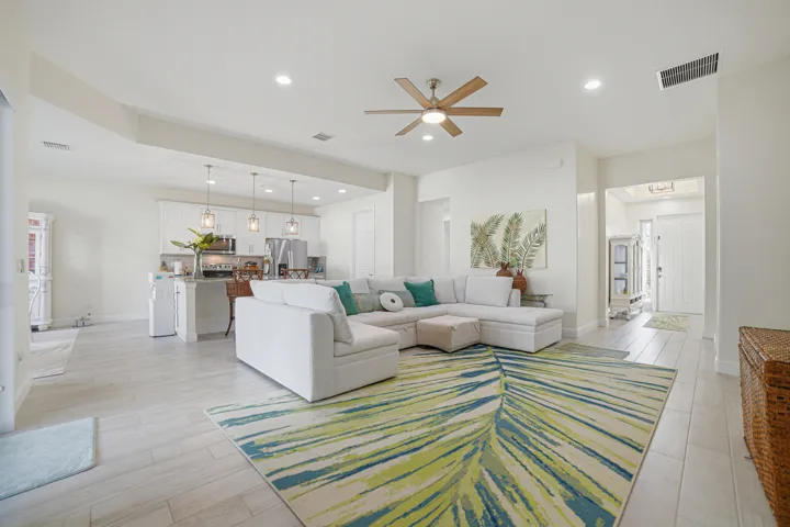 Open-concept living space featuring wood-finish flooring, recessed lighting, and a ceiling fan