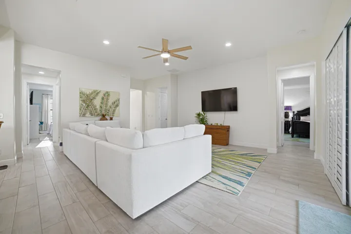 Open-concept living area with plank-style flooring, recessed lighting, and a ceiling fan