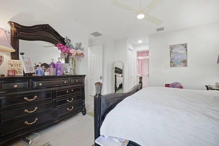 White walls, tile flooring, ceiling fan, and a white interior door