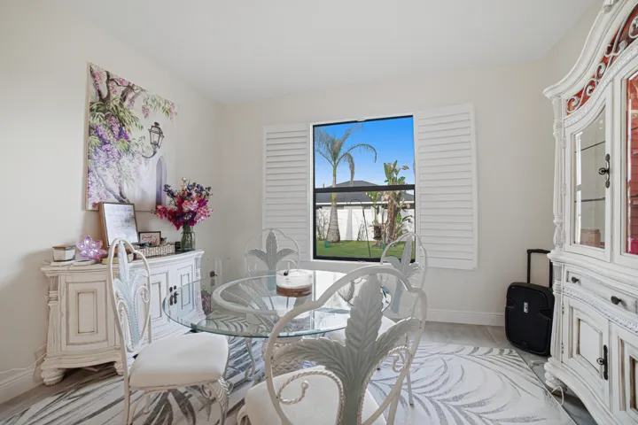 Light-toned walls, wood-finish flooring, and a window with plantation shutters