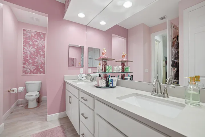Dual vanity with white cabinetry, light-colored countertops, and brushed nickel fixtures