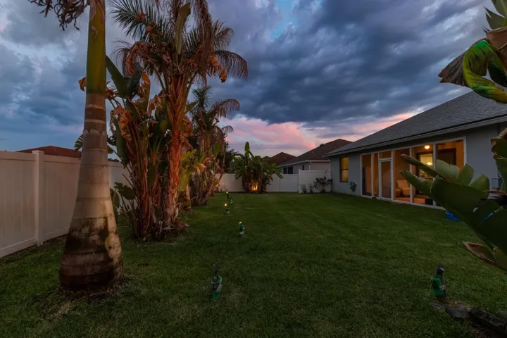 Expansive lawn with perimeter fencing, illuminated by ground lighting