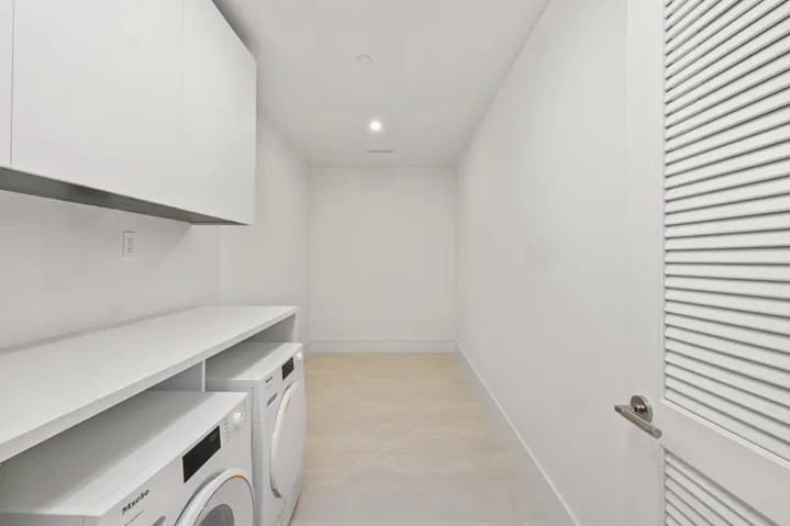 Large Laundry area featuring recessed lighting, a built-in countertop, white upper cabinetry, and light-toned flooring