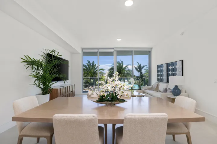 Spacious living area featuring a light wood-finish dining table and light-colored flooring