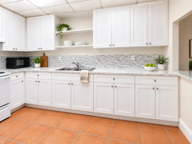 Kitchen featuring white shaker-style cabinetry, stone-finish countertops, decorative tile backsplash, open shelving, and terra-cotta tile flooring