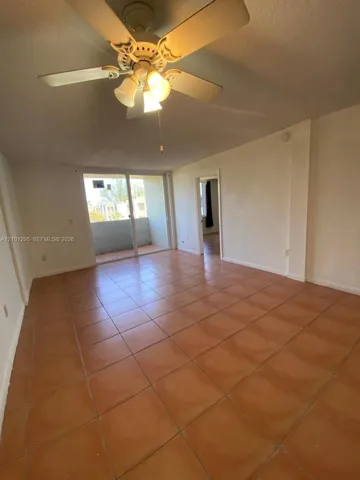 Ceramic tile flooring, ceiling fan with integrated lighting, and sliding glass door with external access