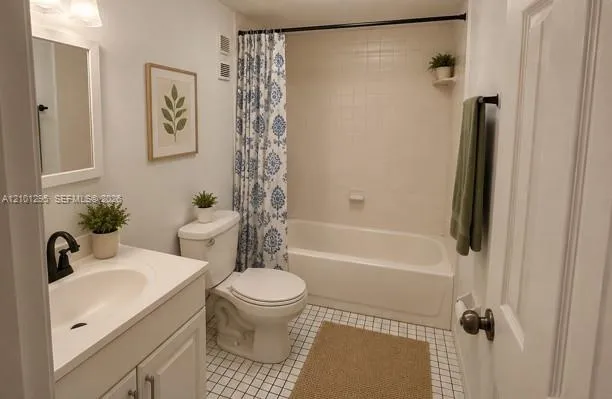 Bathroom featuring a white vanity cabinet, integrated sink with matte black faucet, tiled tub surround, and grid-patterned floor tile