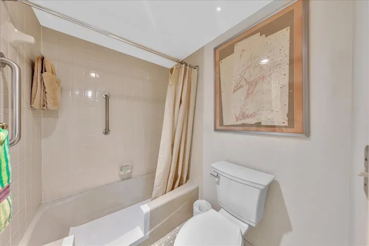 The spacious primary suite offers added convenience and accessibility, with the bathtub modified for easier walk-in entry and additional grab bars. 
