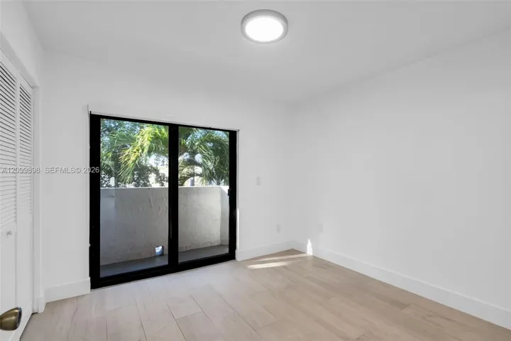 This is the view looking to the North and the second bedroom has sliding glass doors that open to a small balcony! The second floor landing and both Bedrooms and have the same tile floors. Notice the nice Palm trees that are just off the North facing balcony.