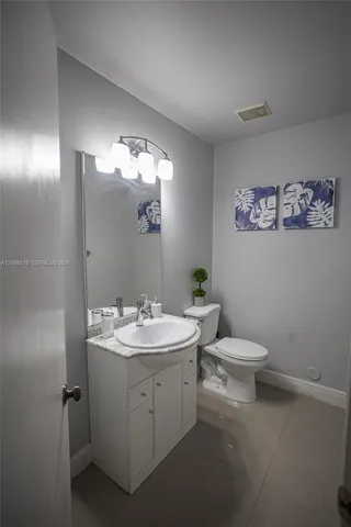 Guest bathroom with a white vanity and simple, timeless finishes.