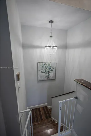 Upstairs landing with a pendant light and an open railing.