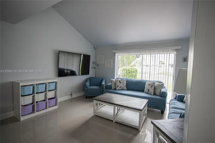 Vaulted ceilings and a wall of windows fill the living room with soft natural light.
