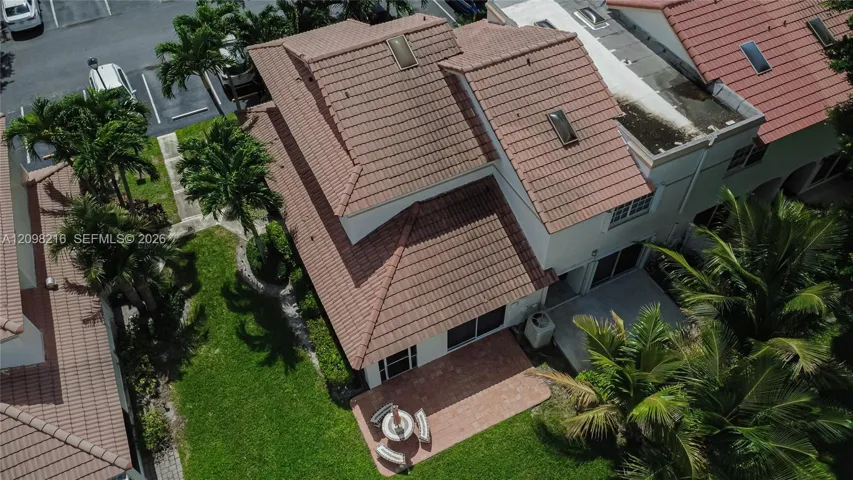 Aerial view showing the home's setting among palms and lush greenery.