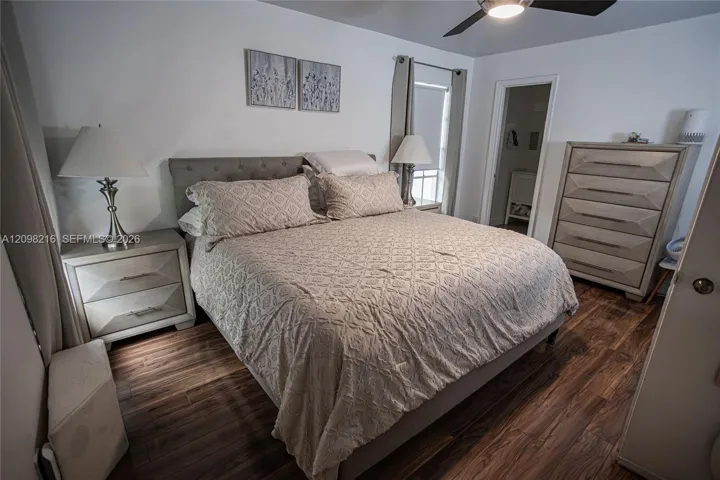 Serene bedroom with wood style flooring, a ceiling fan and room for a full furniture suite.