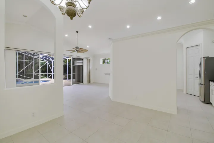 Recessed lighting, arched doorways, tile flooring, pool enclosure, and ceiling fan