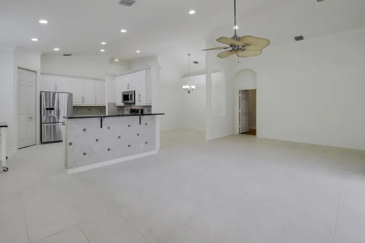 Open concept living area with vaulted ceilings, recessed lighting, and tile flooring