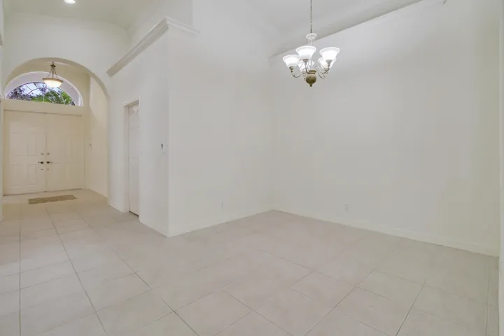 Arched entryway with double doors, vaulted ceiling, recessed lighting, and tile flooring