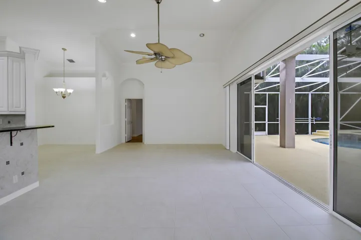 Spacious interior with neutral tile flooring, high vaulted ceilings, and recessed lighting