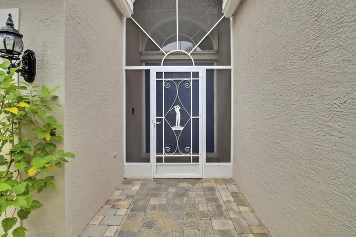 Stone paver entry with stucco exterior and screened porch