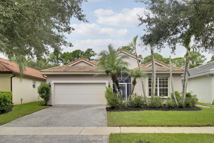 Mediterranean-style residence featuring a tile roof, stucco exterior, and an attached two-car garage