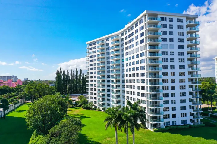 Curved high-rise exterior with multiple balconies featuring glass railings