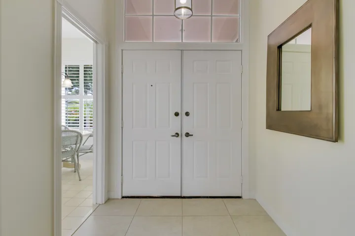 Double entry doors with transom window and tile flooring