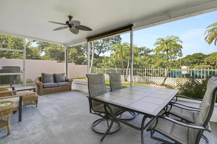 Screened lanai with ceiling fan and retractable shade, overlooking the lake