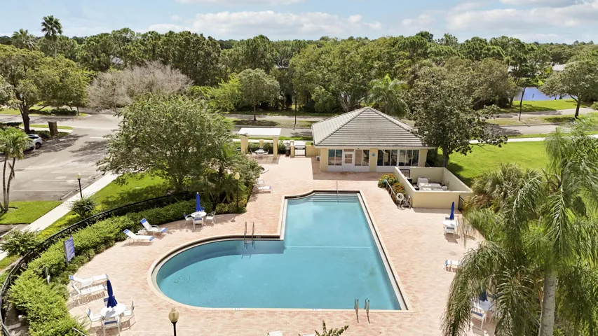 Community swimming pool and bathrooms with a surrounding paver deck
