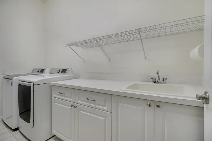 White cabinetry laundry room with laundry sink