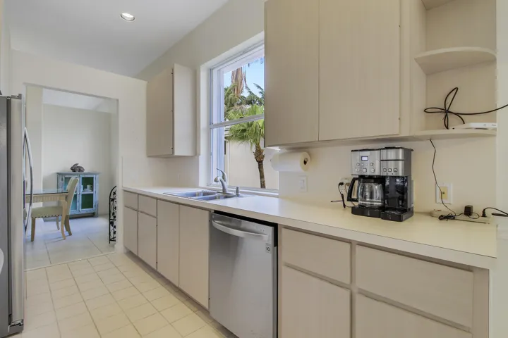 Kitchen cabinetry features plenty of storage, a stainless steel appliances, and a window above the sink