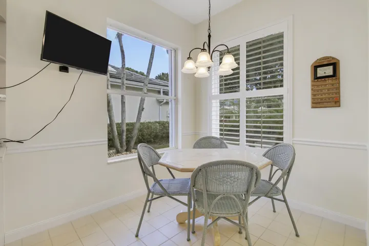 Tile flooring, window with exterior landscaping, window with plantation shutters, decorative chair rail molding.