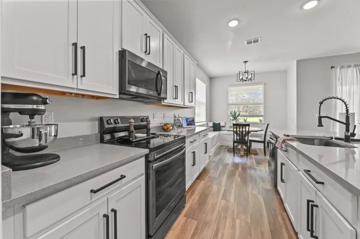 Black Stainless Steel Appliances, smooth top range with built-in microwave oven and high hat lighting