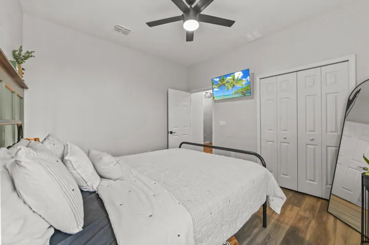 Guest Bedroom with ceiling fan and wood style flooring