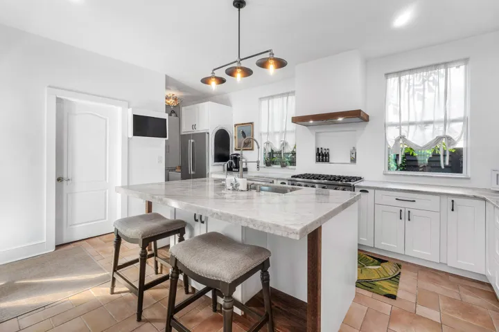 Professionally styled kitchen, center island, and gas range.
