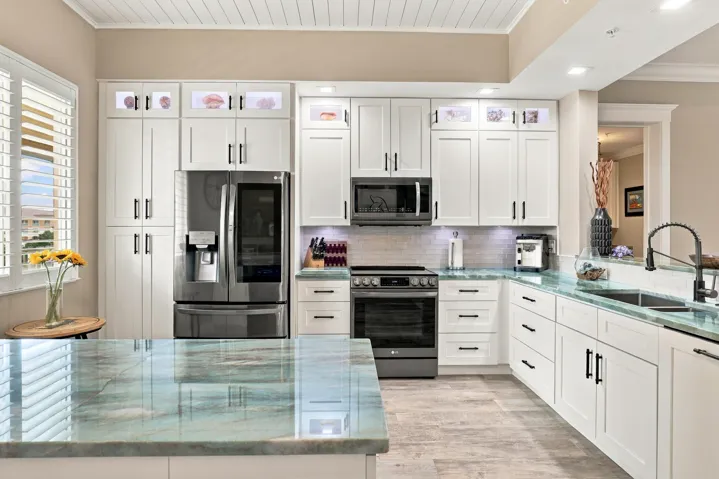 Soft Close Wood Cabinetry with Black Hardware and Pull-Out Shelving. Under Counter Drawers Substituted for Cabinets to Provide Easier Access to Every Day Items